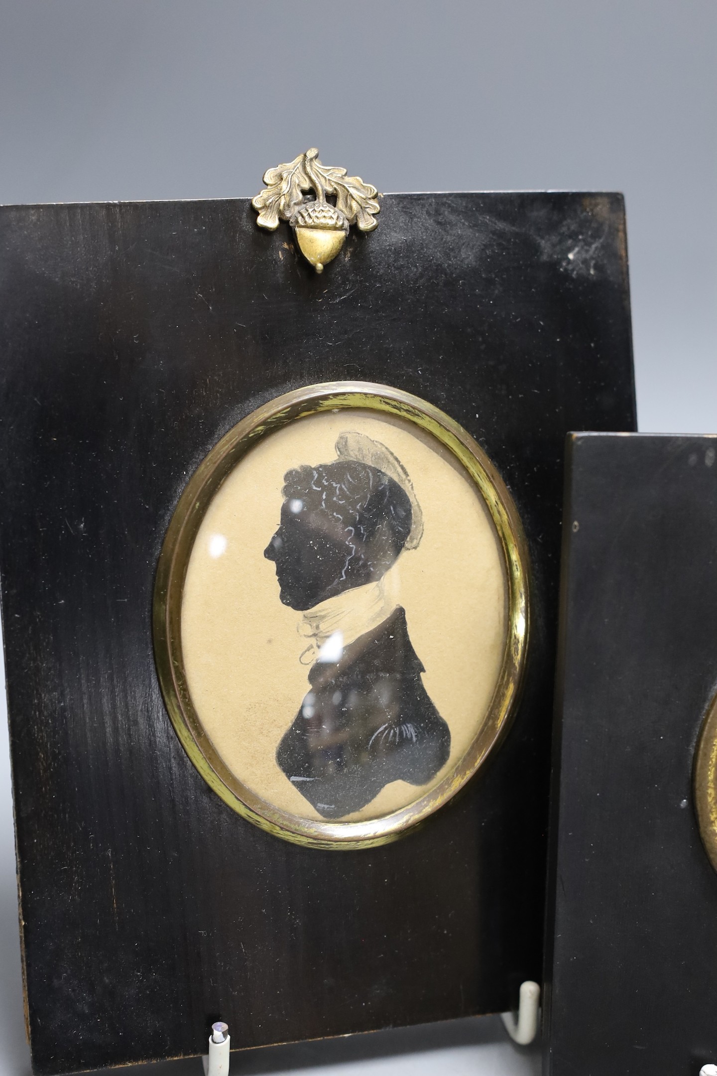 An unusual portrait miniature of a 19th century gentleman wearing earrings, together with two framed silhouettes (3)